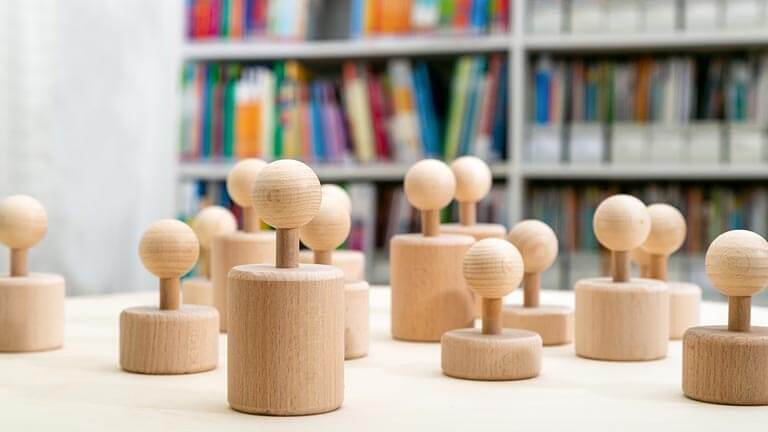 im Vordergrund Spielsteine, im Hintergrund Regal mit Büchern im Vordergrund Spielsteine, im Hintergrund Regal mit Büchern